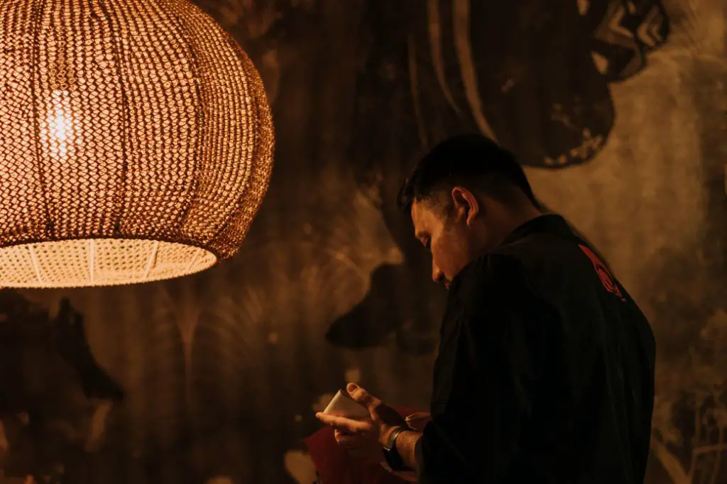 person reading a book under pendant light