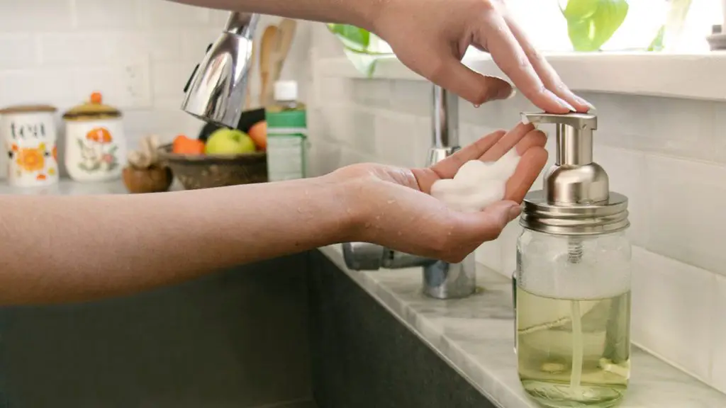 person refilling a soap pump dispenser