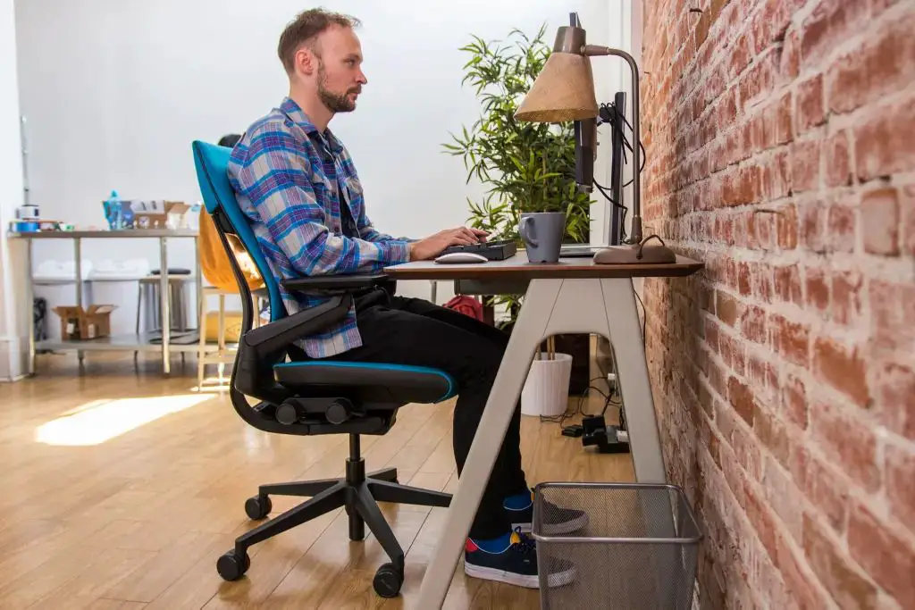 person sitting in an ergonomic office chair at a desk