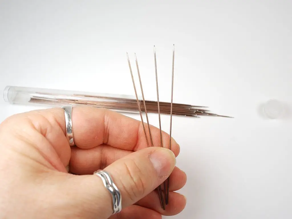 person using clay tools and cutters to shape polymer clay beads