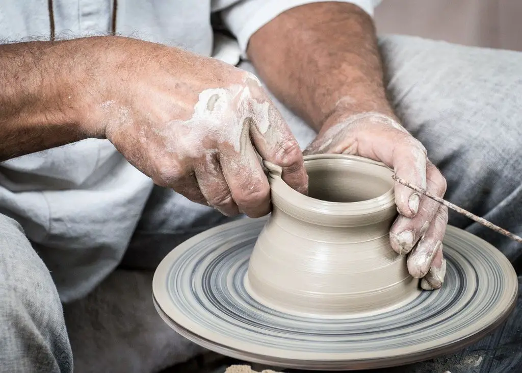 person using various pottery wheel shaping techniques