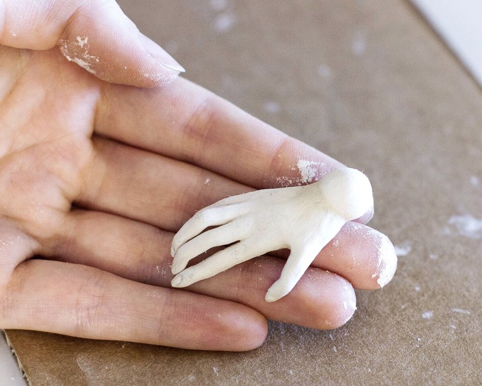 person's hands kneading and shaping air dry clay