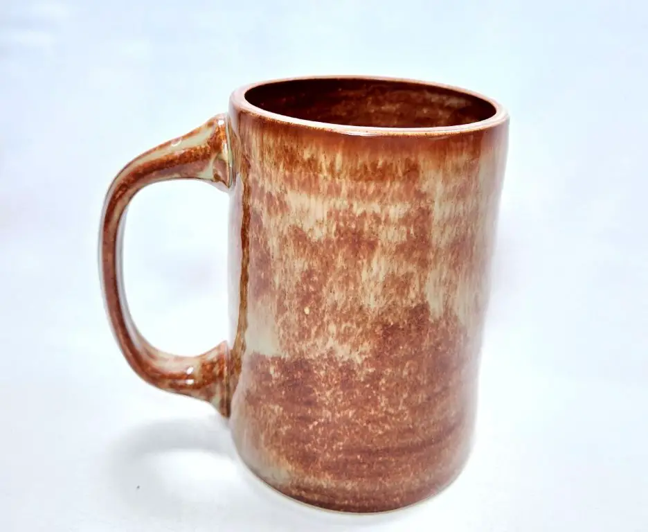 photo of a handmade pottery mug with a dishwasher safe label on the bottom