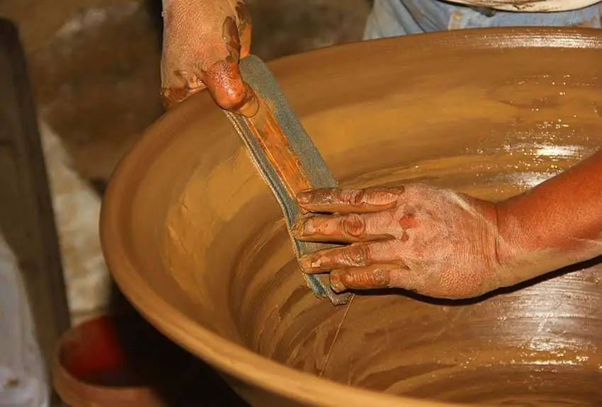 photo of artisan applying lead-free glaze to mexican clay pot