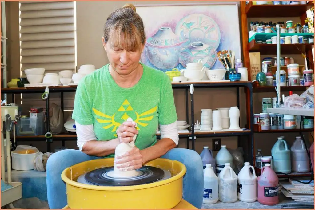 proper posture with a straight spine helps gain control when centering clay on the pottery wheel.