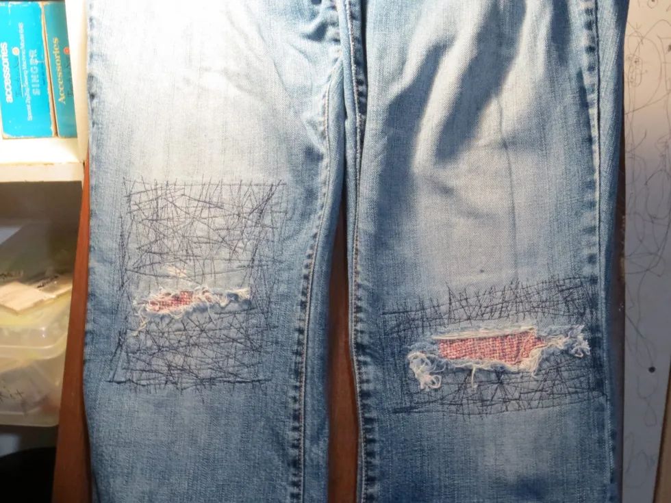 repairing a hole in jeans by sewing a denim patch involves cutting a patch larger than the hole, pinning it underneath, and stitching the perimeter.
