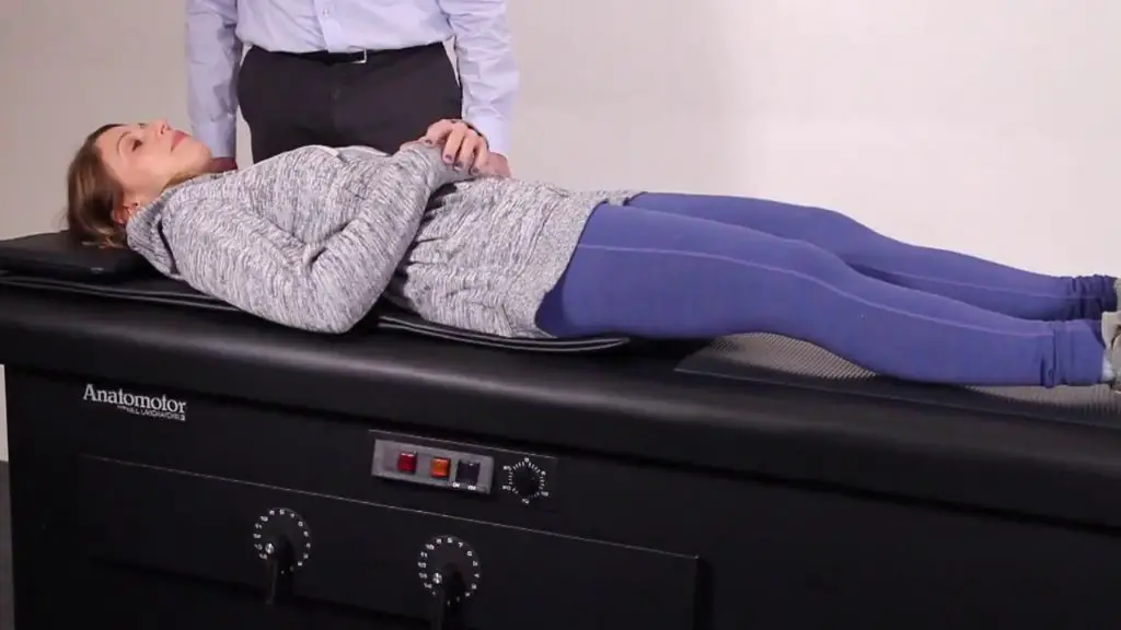 someone receiving a back massage on a roller table