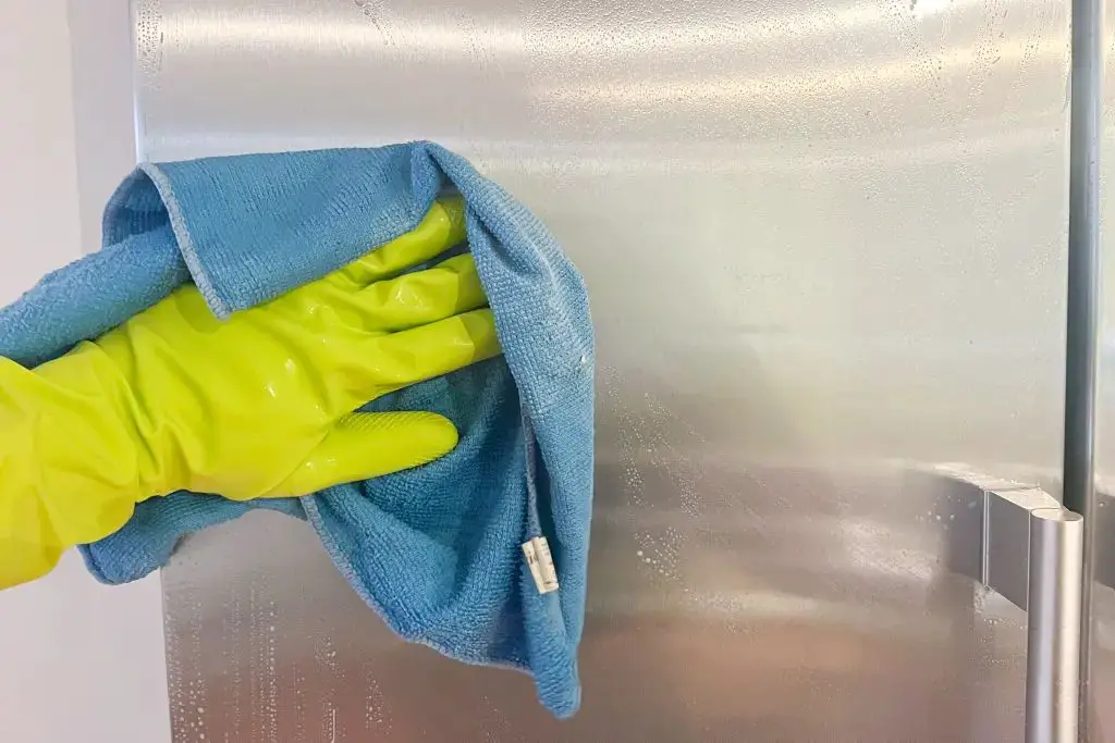 someone scraping a metal surface wearing gloves