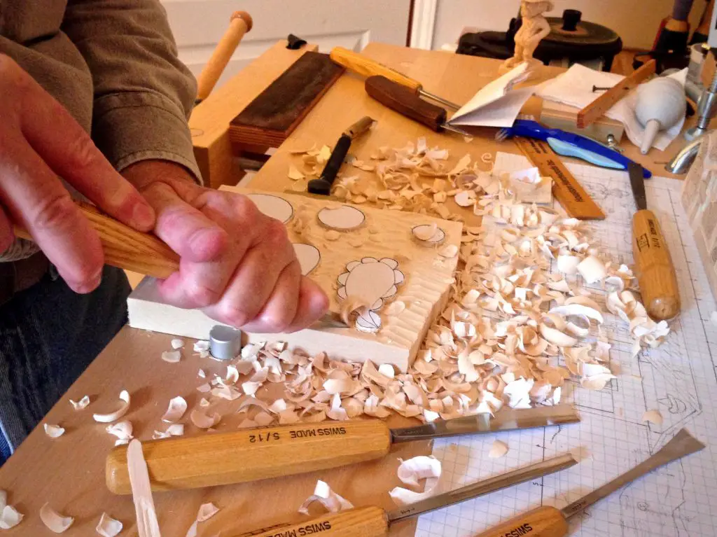 someone using wood carving tools to make a stamp