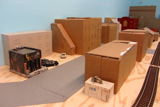 testing a model train layout design with cardboard mockup pieces.