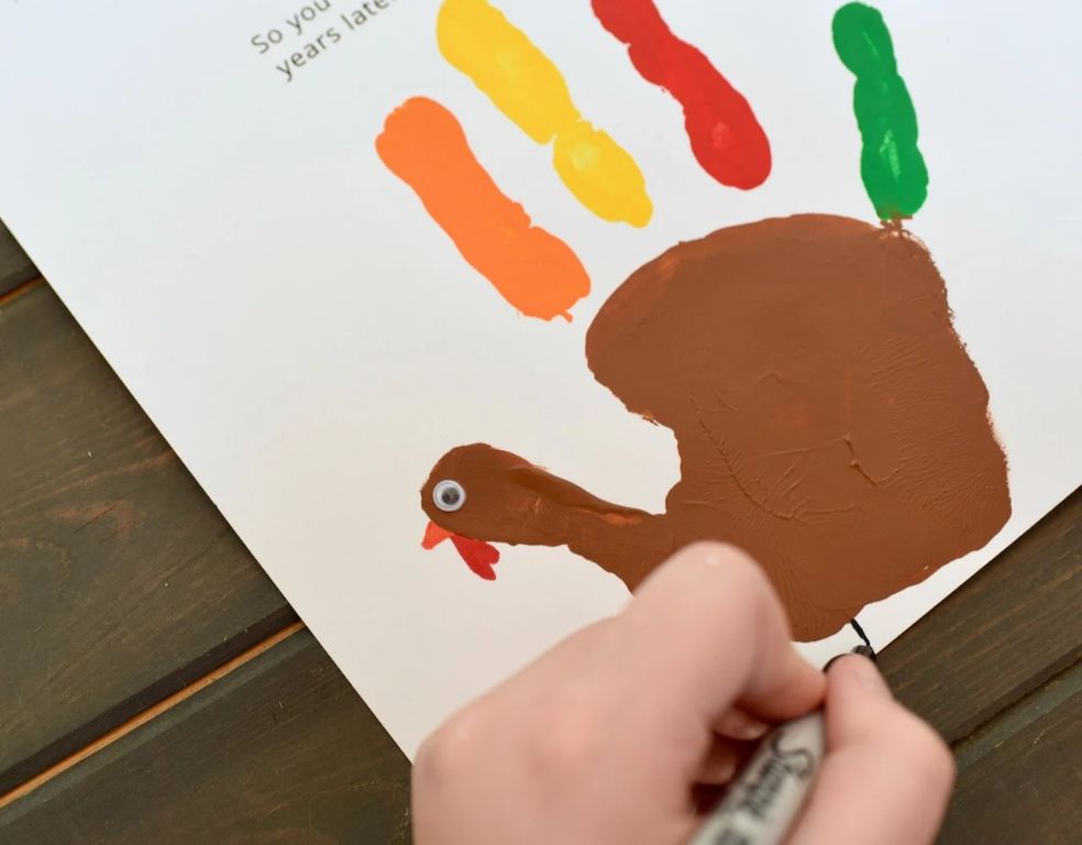 tracing a child's handprint is the first step in making a handprint turkey craft