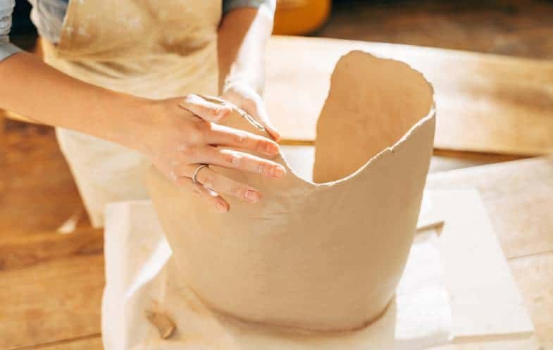 trying different handbuilding techniques like pinch pots allows beginners to start creating basic ceramic forms and vessels to get a feel for working with clay.