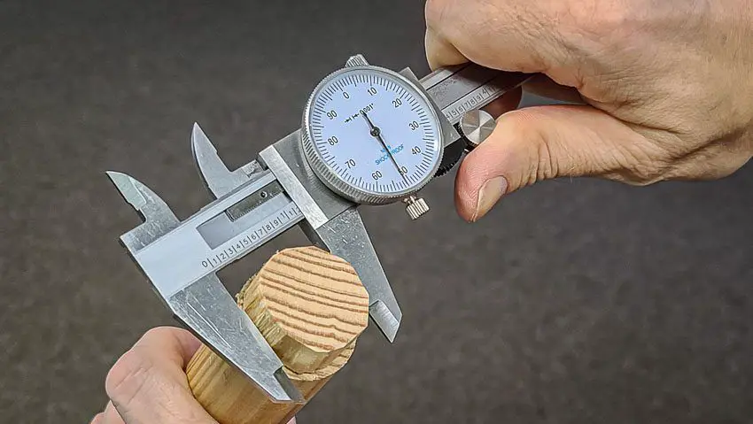 using calipers to precisely measure a small part.