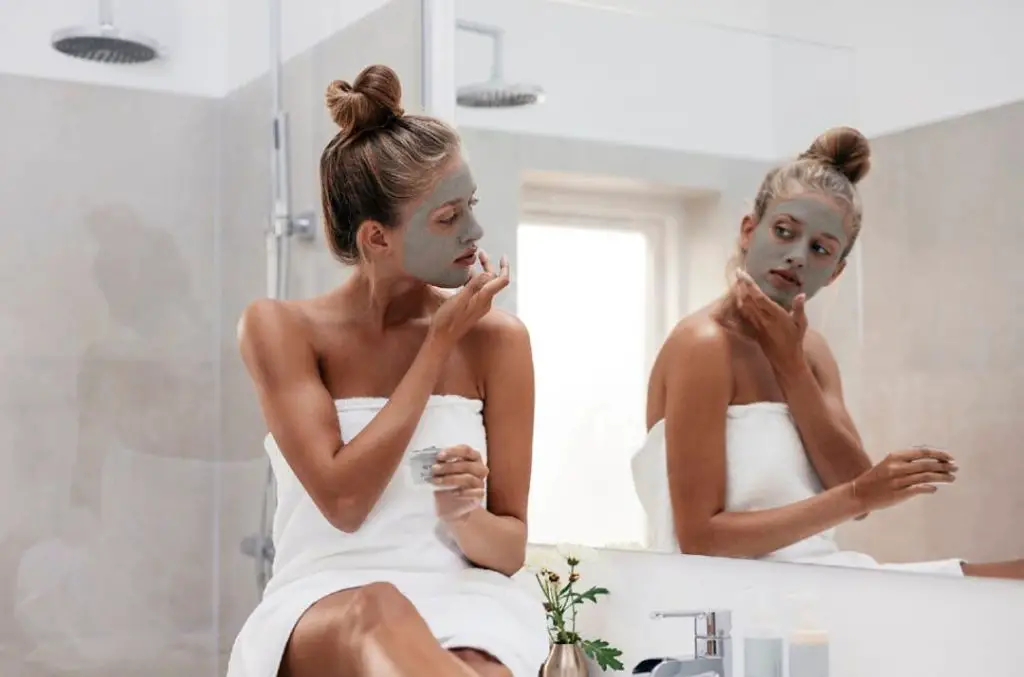 woman applying a bentonite clay face mask.