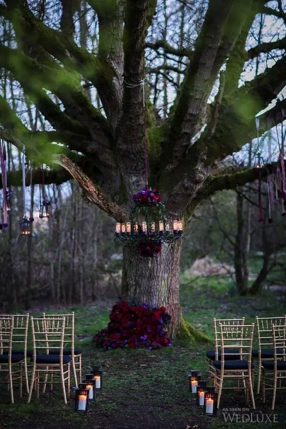 Moody florals on the tree and chandelier make the ceremony spot chic