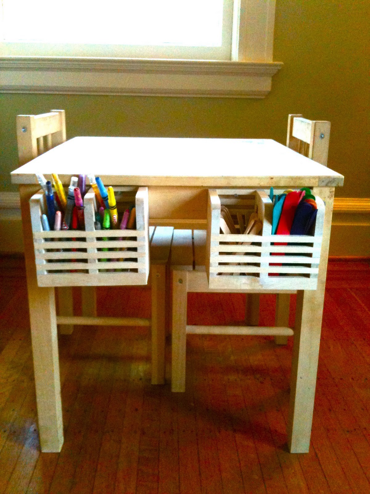 Place wooden boxes on the sides of a children’s table so that children can keep their colors