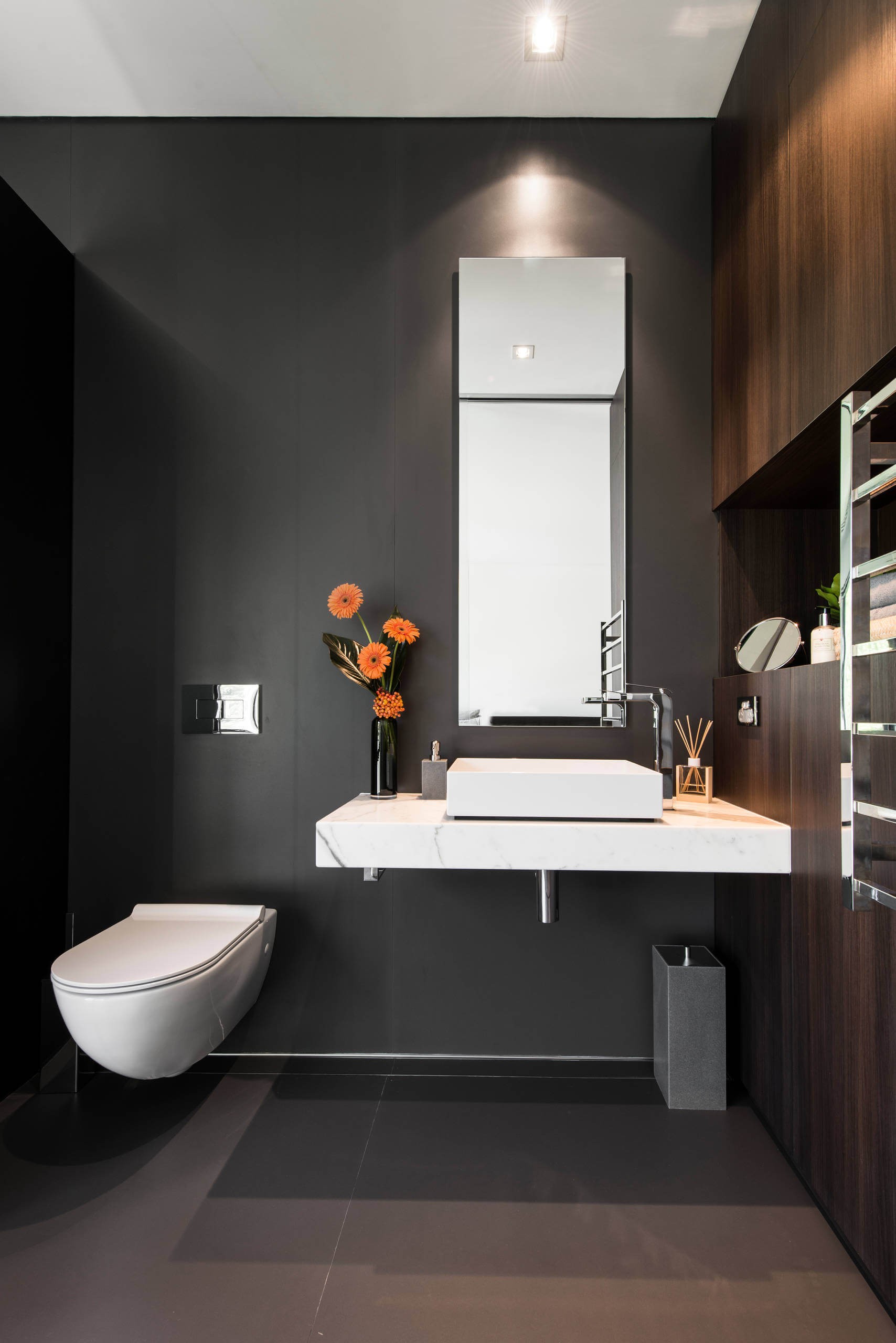 #17. Ceramic floor powder room with a vessel sink, dark wood cabinets, marble countertops, a wall-mount toilet and black walls