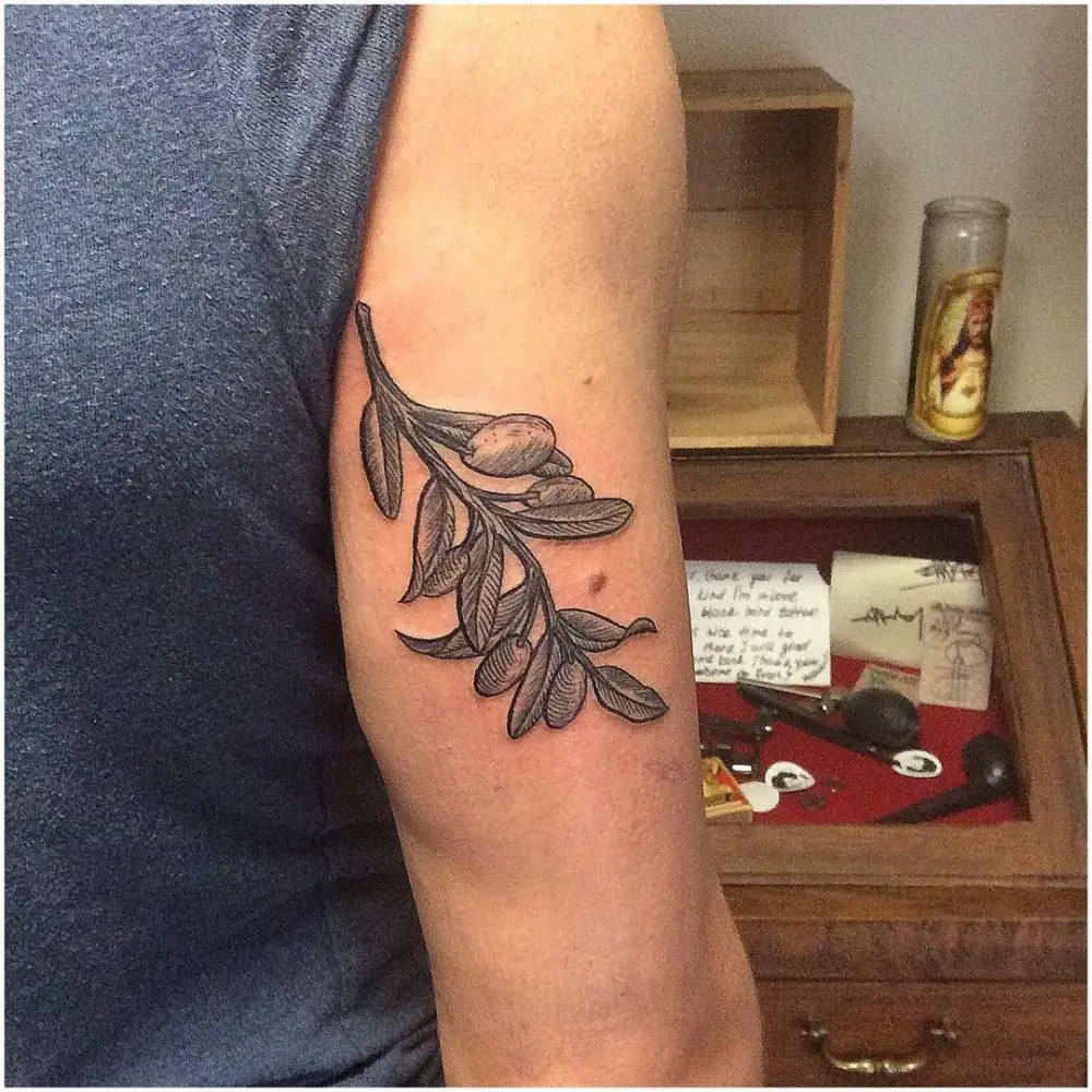 #3. The arm olive branch tattoo symbolizing victory.