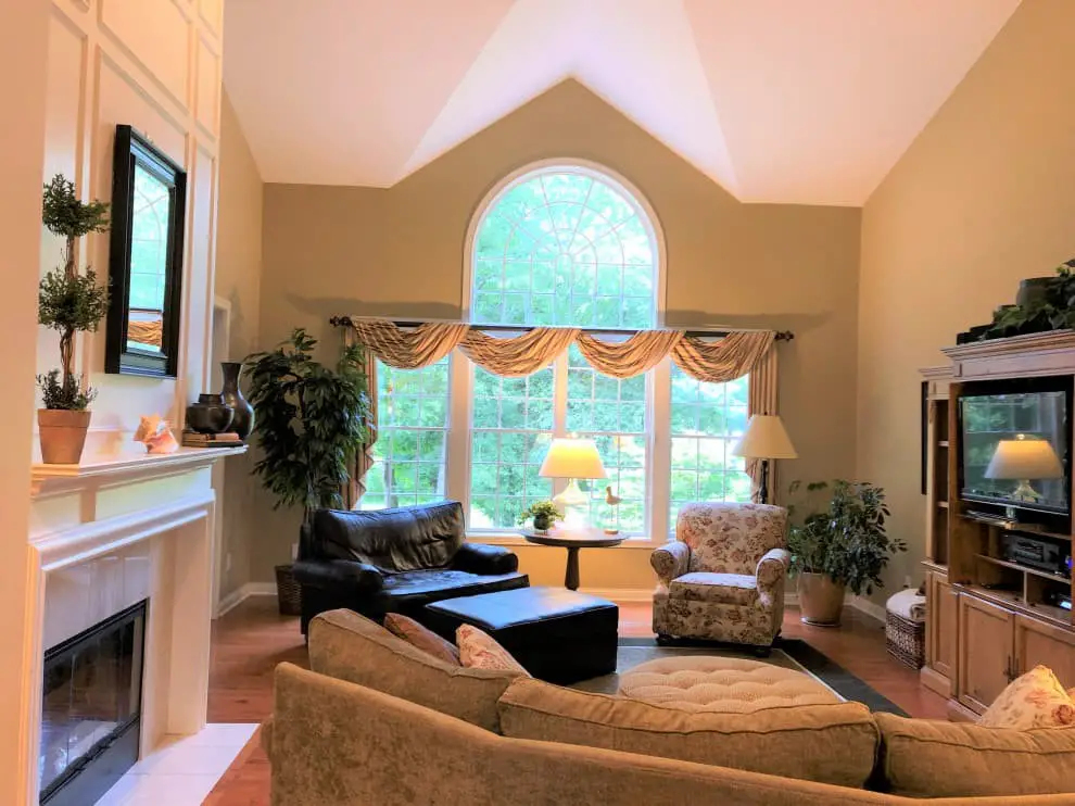 At the opposite ends of the room, there is a fireplace and a television.