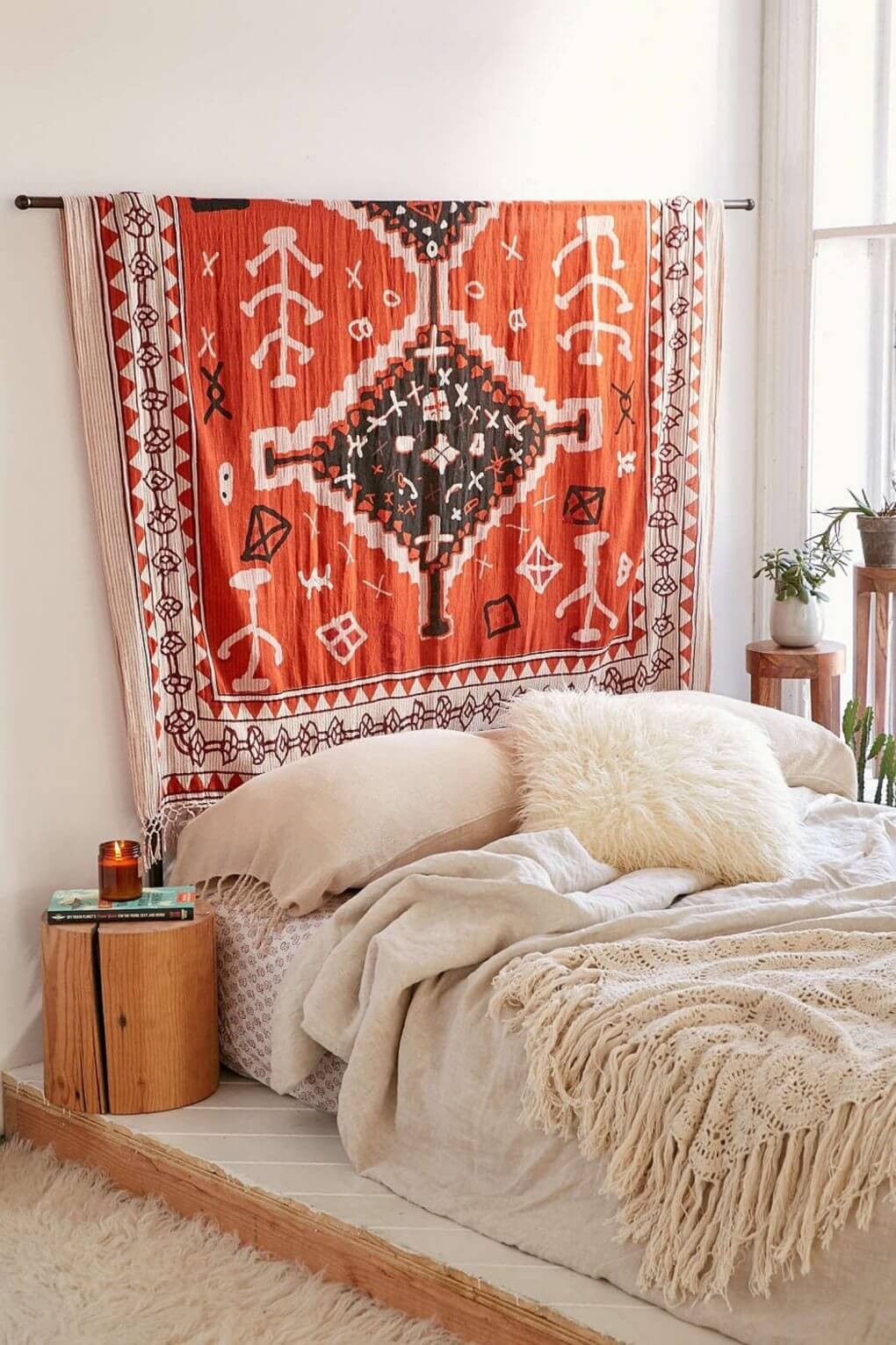 Minimal Bedroom With Leafy Decor and a Patterned Rug Above the Bed