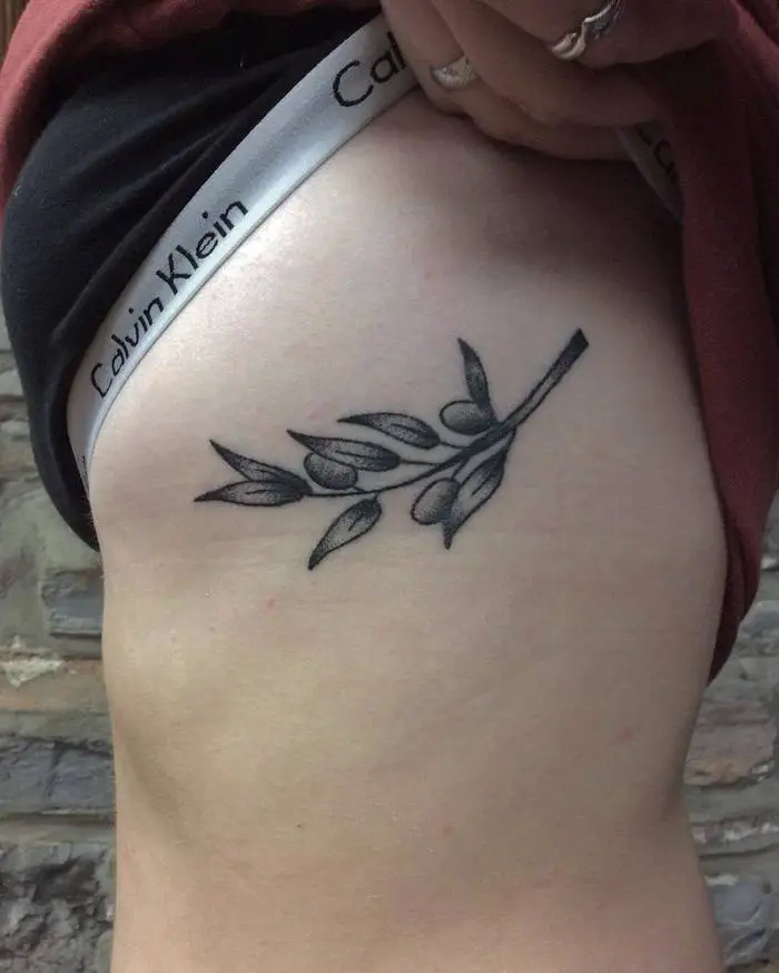 #1. The rib-cage olive branch tattoo symbolizing life and longevity.