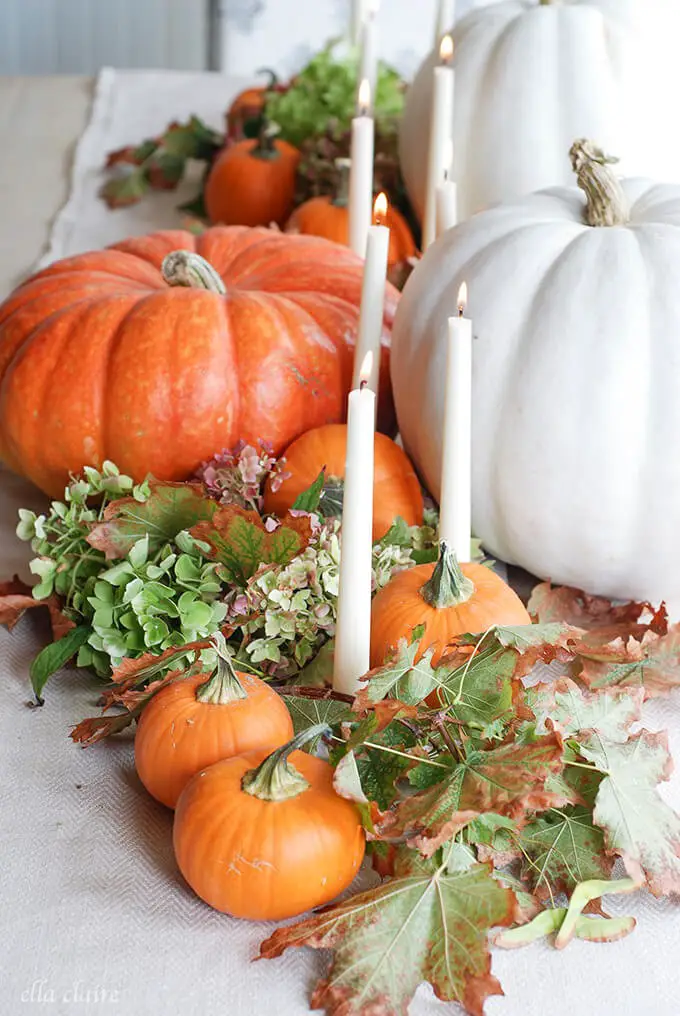 White Candles amongst Pumpkins