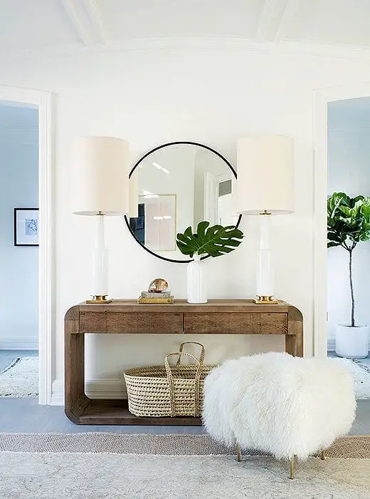 A round mirror above a console table