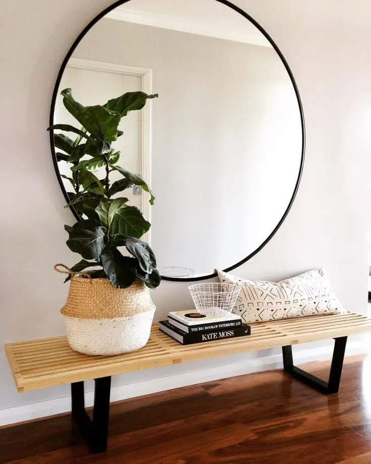 Large round mirror above a bench