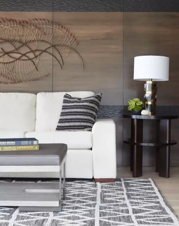 White couch against a wood paneled wall