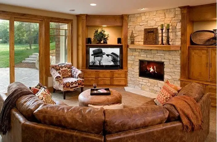 A living room arrangement with a corner TV over the fireplace