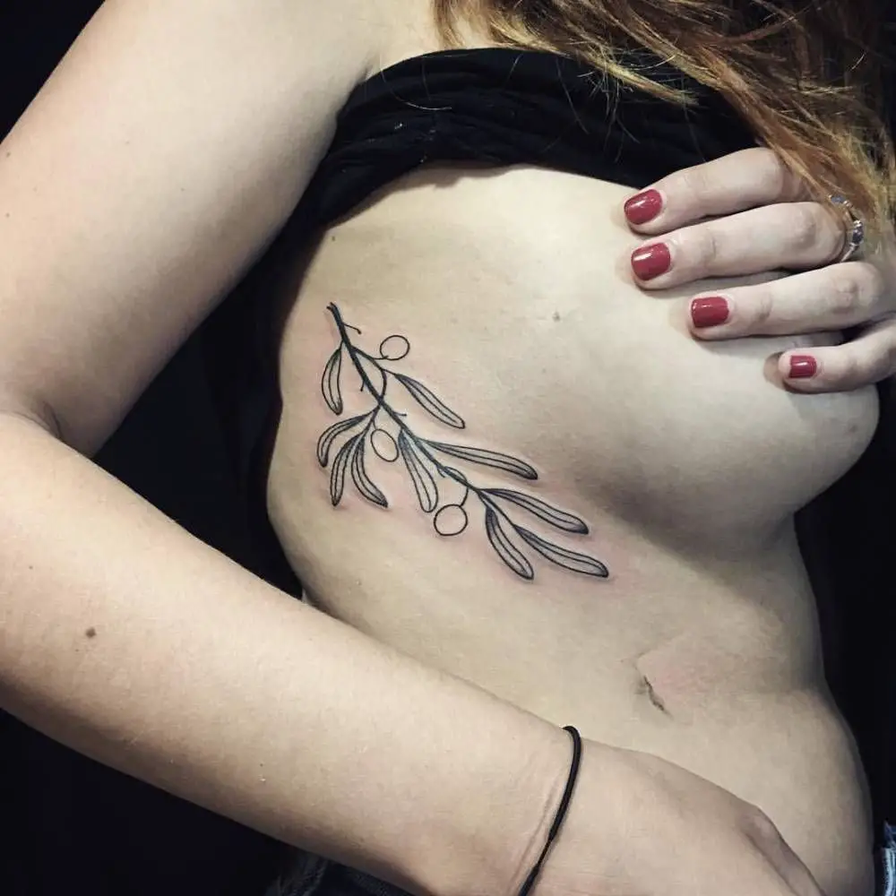 #1. The rib-cage olive branch tattoo symbolizing life and longevity.