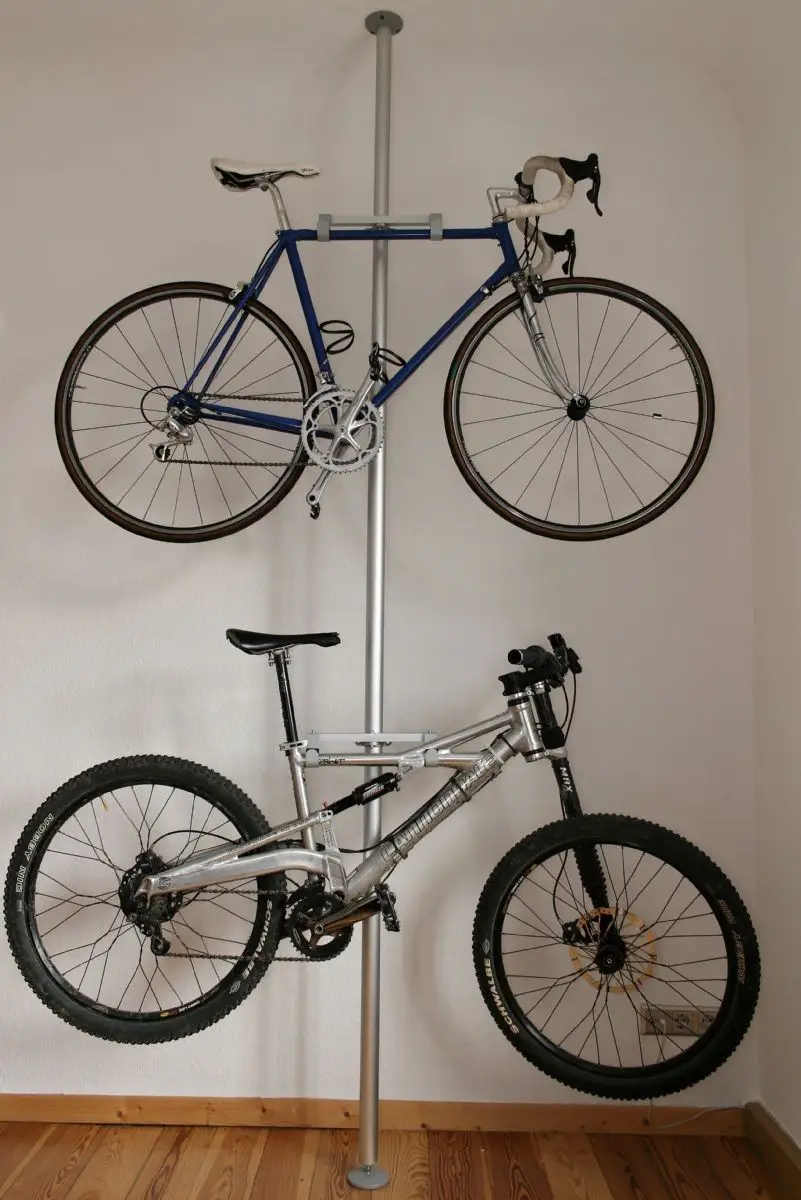 Use an aluminum pole and attach it to the wall with supports to hang the bicycles