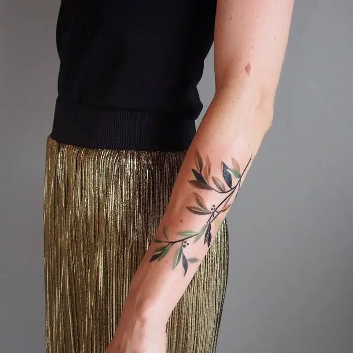 #3. The arm olive branch tattoo symbolizing victory.