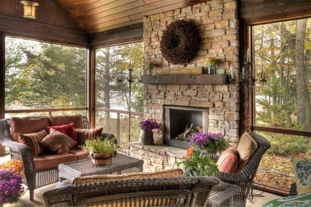 Rustic screened in porch with fireplace.