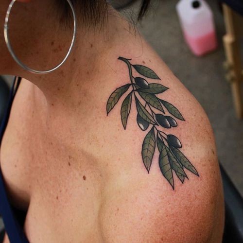 #2. The shoulder olive branch tattoo symbolizing peace and dignity.