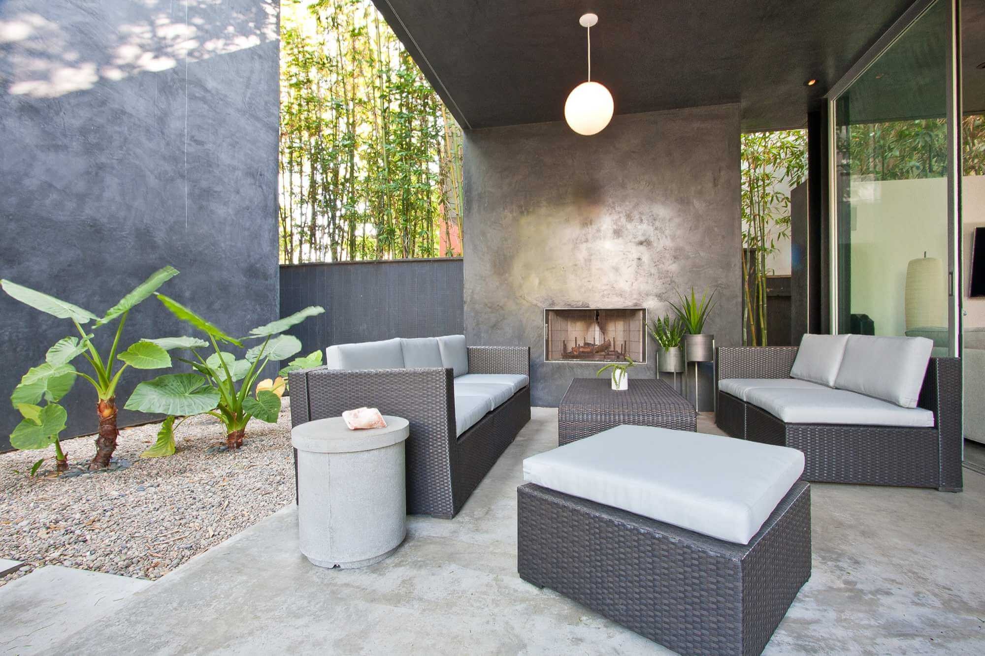 #7. Contemporary concrete patio remodel with a fire pit and a roof extension