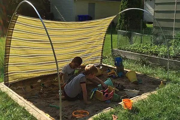 Clever use of tubes for creating shade over lawn that moves with sun