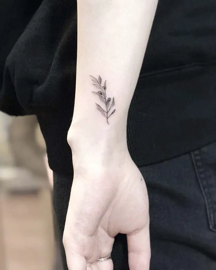 #3. The arm olive branch tattoo symbolizing victory.