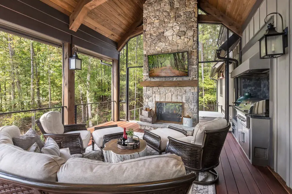 Rustic screened in porch with fireplace.