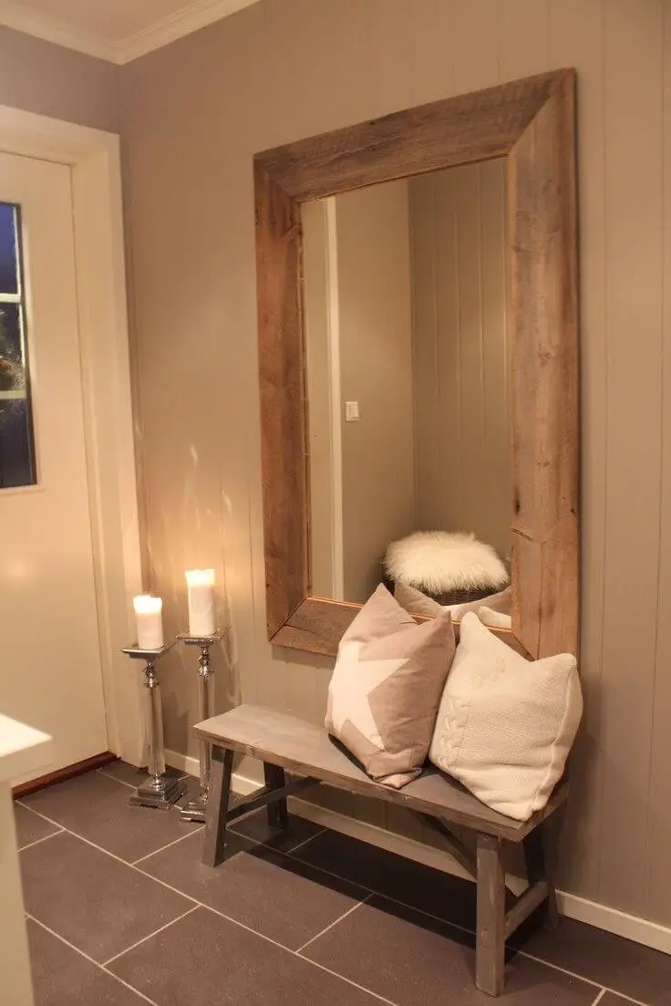 Large framed mirror above a wood bench