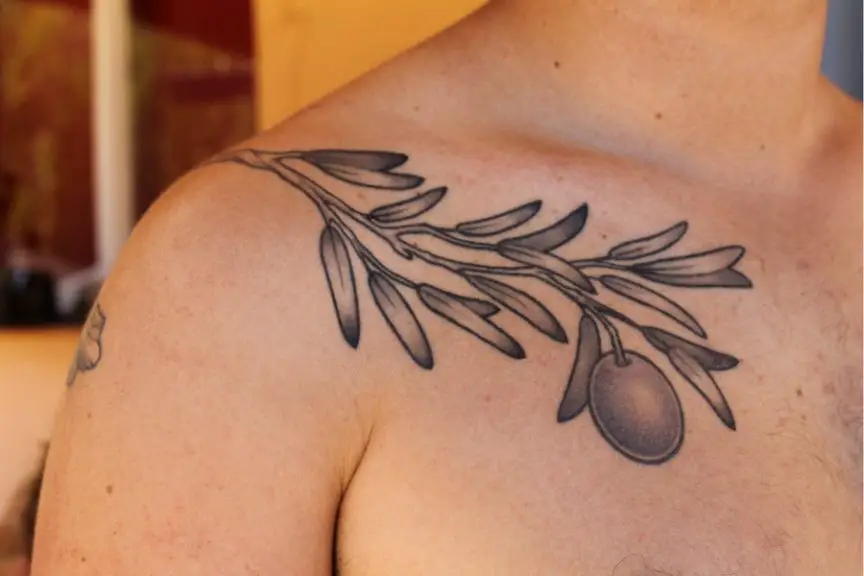 #2. The shoulder olive branch tattoo symbolizing peace and dignity.