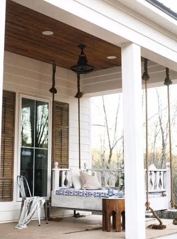 A swing bed on a back porch