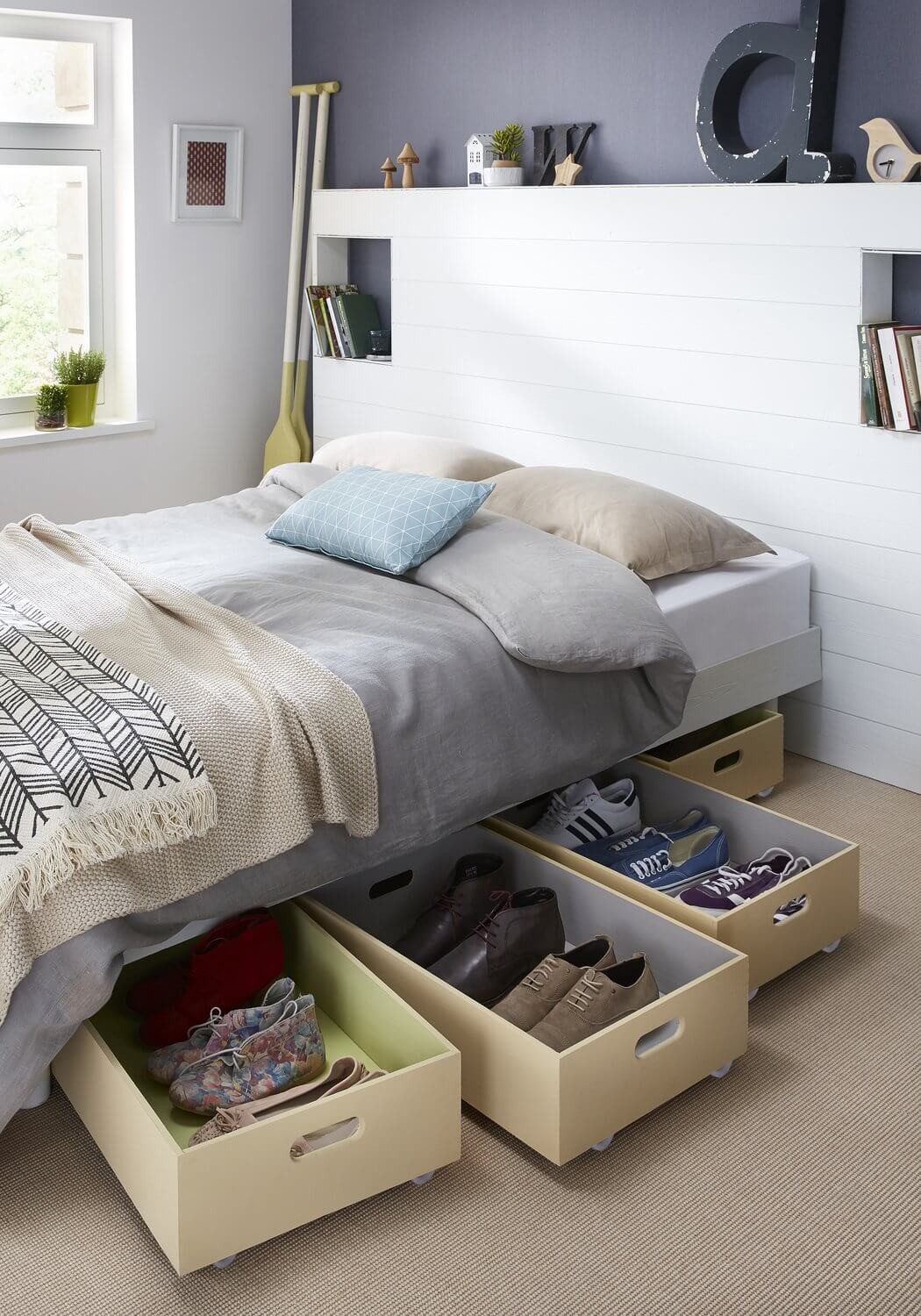 Wooden boxes mounted on wheels hidden under the bed